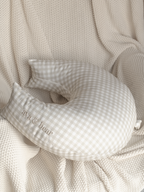 Crescent moon-shaped nursing cushion by Ava & Bear, crafted from 100% cotton twill in a stone gingham pattern, offering optimal support and comfort for mom and baby with its semi-firm structure and eco-friendly design.