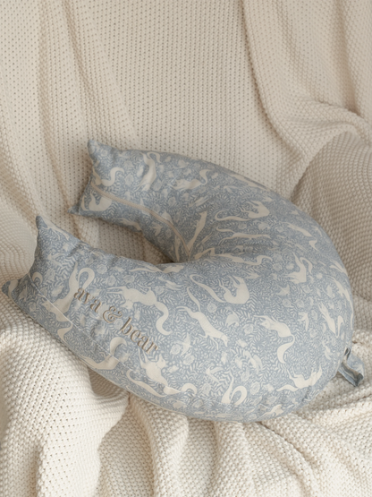Crescent moon-shaped nursing cushion by Ava & Bear, crafted from 100% cotton twill, providing optimal support for mother and baby, with eco-friendly prints and a convenient loop handle for easy portability.